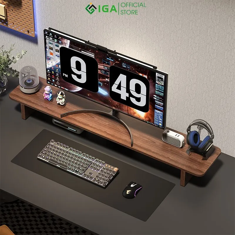 Kệ màn hình IGA GA28 màu óc chó dài trải ngang bàn, trên kệ có màn hình, loa và giá tai nghe, ảnh IGA Official Store