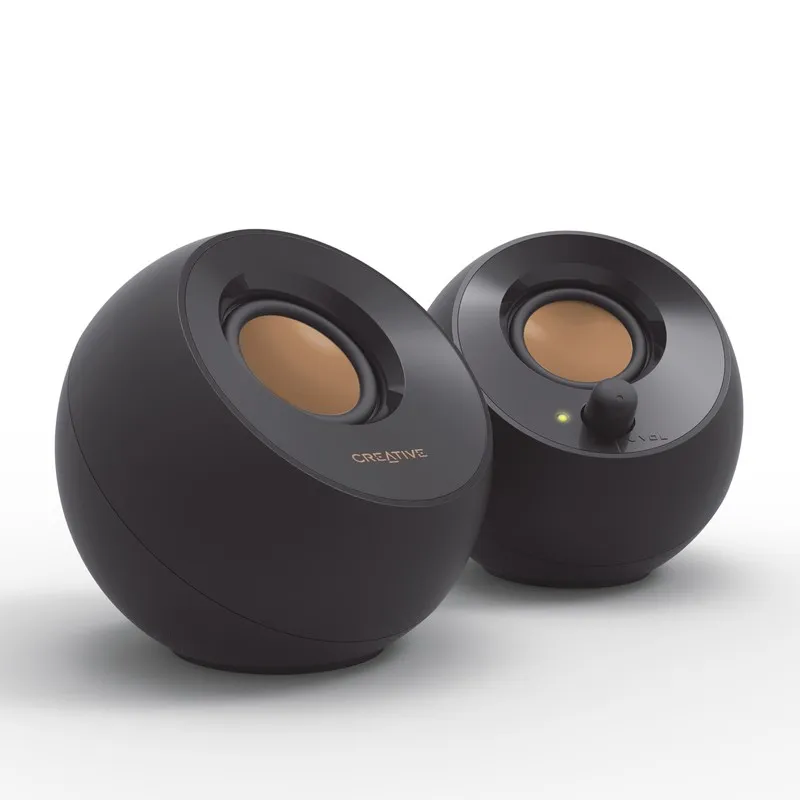 Creative Pebble màu đen nhìn chéo, củ loa màu đồng nghiêng lên, núm âm lượng và đèn báo trên loa phải