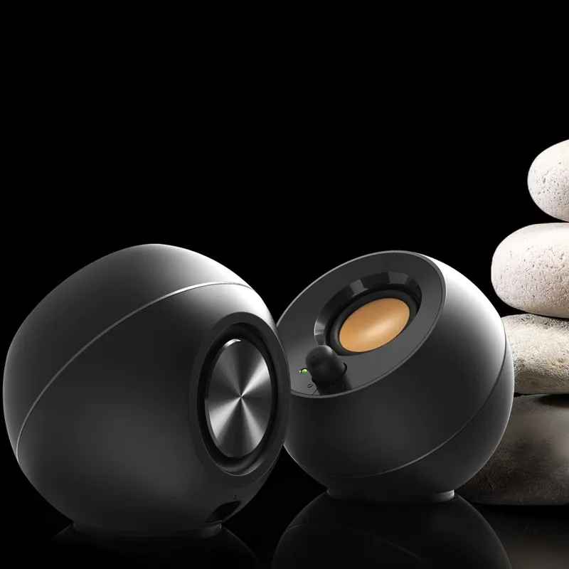 Creative Pebble màu đen trên nền đen cạnh chồng đá cuội, thấy màng cộng hưởng mặt sau